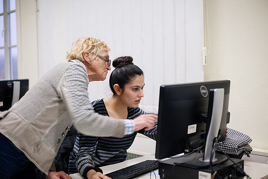 Professorin erklärt einer Studentin etwas am Computer